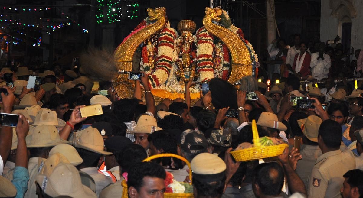 Devotees capture the deity on their mobile phones during the Vairamudi Utsav at Melkote, Mandya district, on Monday night. The deity is adorned with the diamond-studded Vairamudi crown, brought out of the Mandya treasury specially for the annual event. dh photo