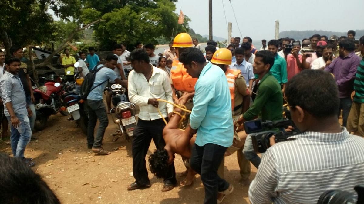 Police and fire services personnel rescue Shankara Banjara who attempted suicide by jumping into the Kali river, in Karwar on Wednesday. DH photo.