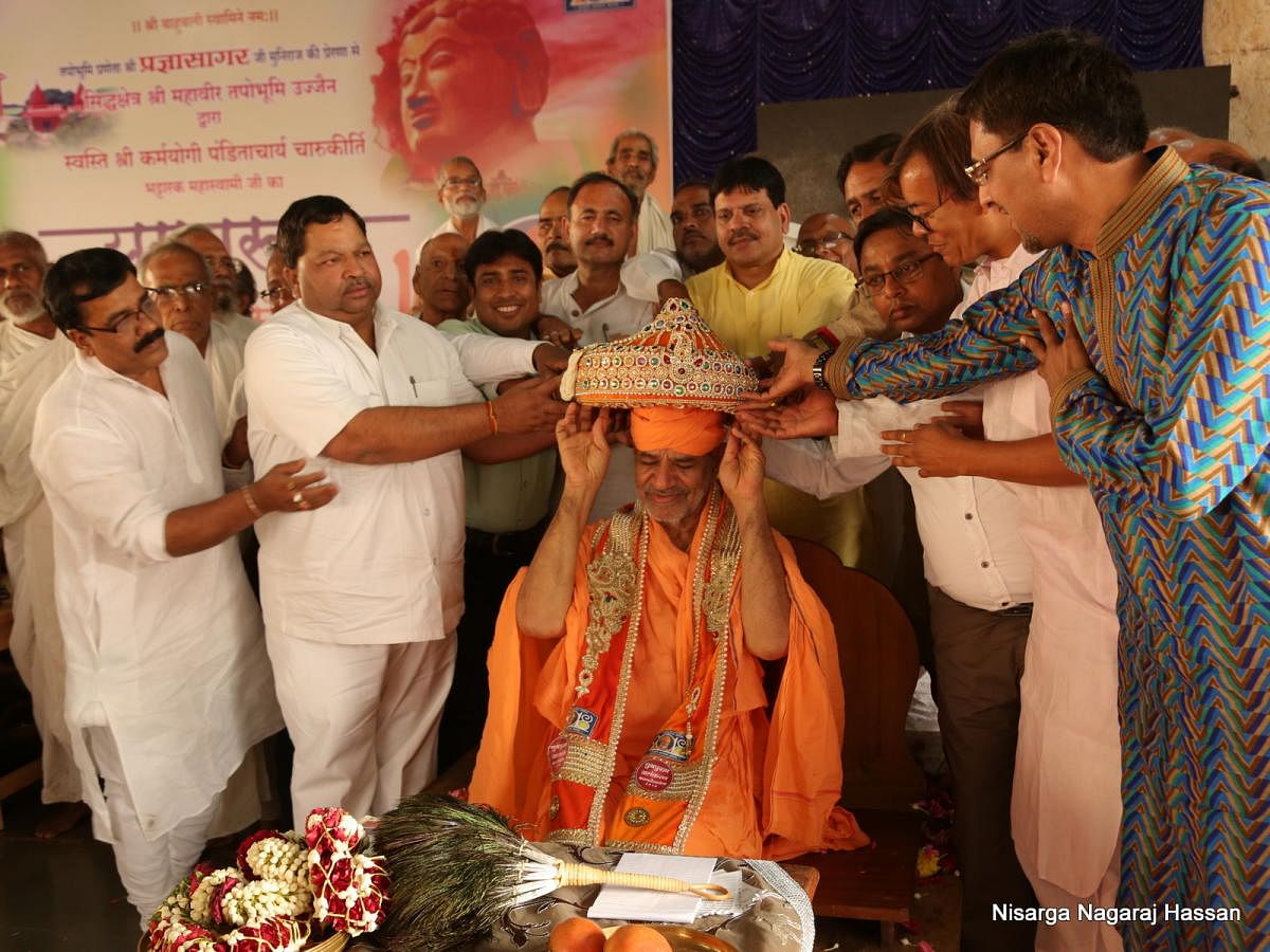 Jain seer Charukeerthi Bhattaraka Swamy being conferred with 'Yugapurusha' award at Chavundaraya Sabha Mantap at Shravanabelagola, Hassan district, recently.