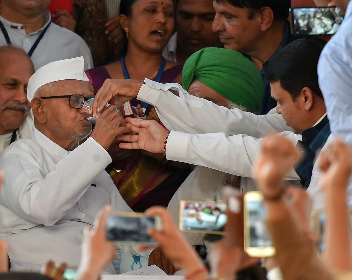 Maharashtra Chief Minister Devendra Fadnavis offers coconut water to social activist Anna Hazare as he ends his six-day indefinite hunger strike after a meeting at Ramlila Maidan in New Delhi, on Thursday. PTI Photo.