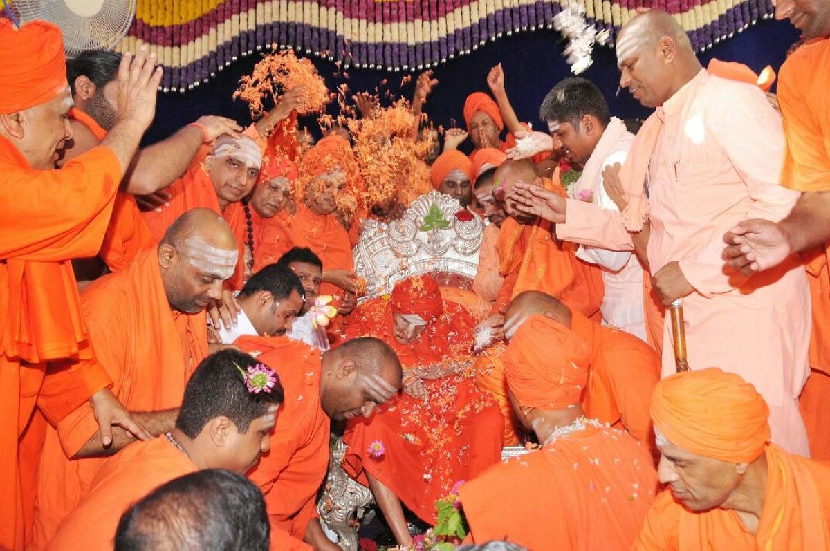 Scores of mutt heads and seers perform Padapuja to Siddaganga seer Shivakumara Swamiji, who turned 111 on Sunday, at the mutt premises in Tumakuru. DH PHOTO