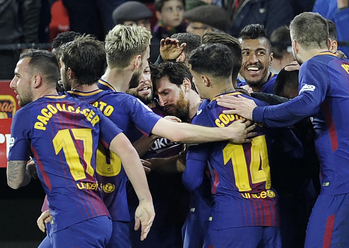 Barcelona players celebrate after Lionel Messi (centre) scored a late equaliser against Sevilla on Saturday. AFP