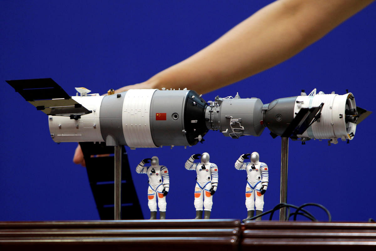 A model of the Tiangong-1 space lab module (L), the Shenzhou-9 manned spacecraft (R) and three Chinese astronauts is displayed during a news conference at Jiuquan Satellite Launch Center, in Gansu province, China. Reuters File Photo