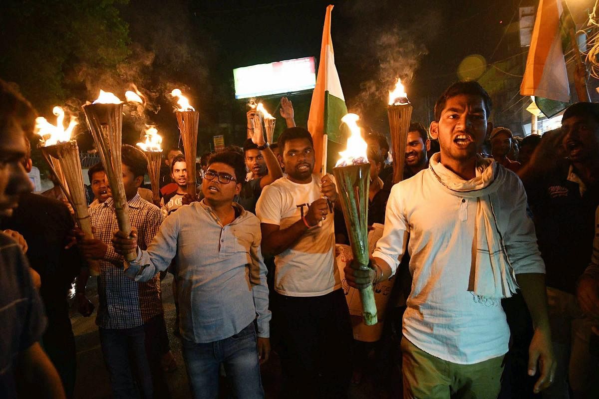 Students of Patna University taking out a torch rally on the eve of 'Bharat Bandh' over the SC/ST Act against the amendment in the law by Supreme court, in Patna on Sunday. PTI Photo