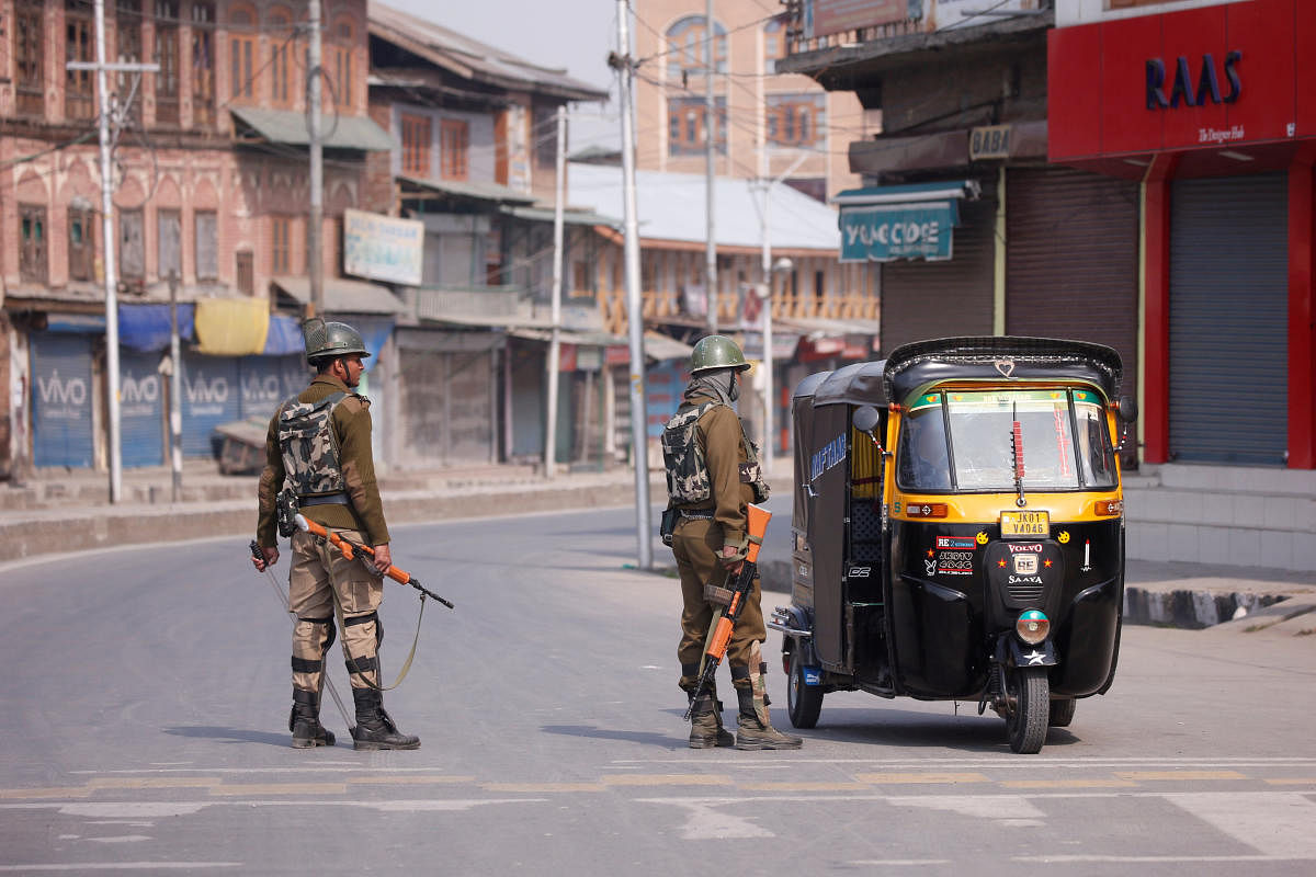 Police personnel stop an autorickshaw after separatists called for a day-long strike against the recent killings in Kashmir, in downtown Srinagar, on Monday. REUTERS