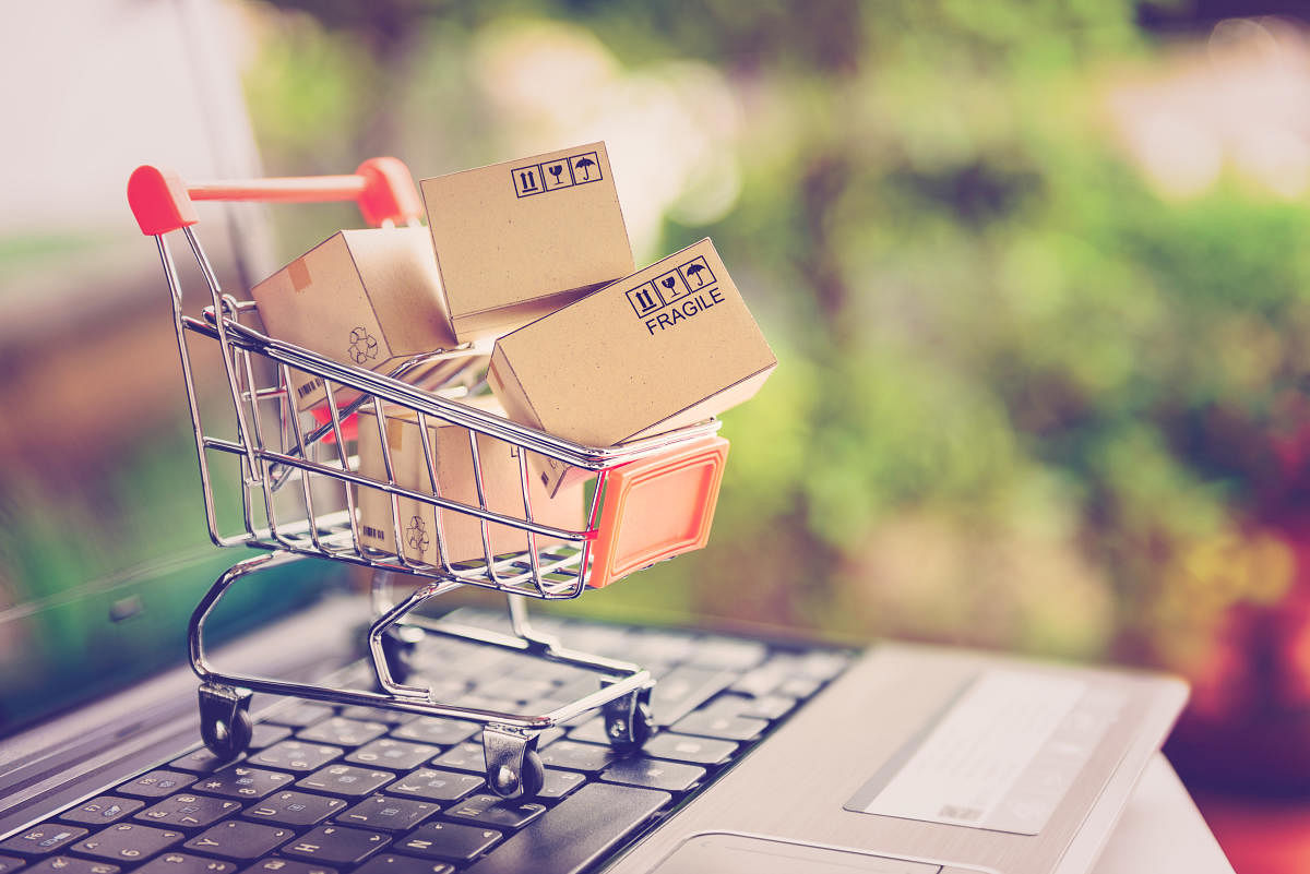 Online shopping and delivery service concept. Paper cartons in a shopping cart on a laptop keyboard, this image implies online shopping that customer order things from retailer sites via the internet.ecommerce