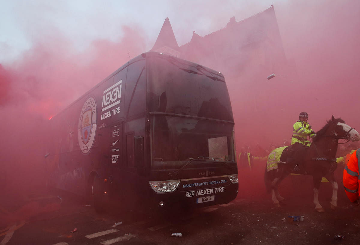 Liverpool fans set off flares and throw missiles at the Manchester City team bus outside the stadium. REUTERS