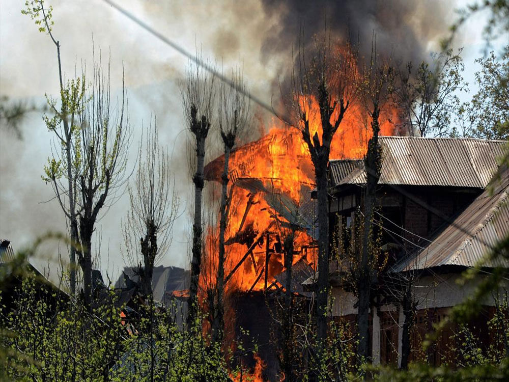 Houses caught fire during a gun battle between security forces and militants in Shopian, of South Kashmir on Sunday.11 militants were gunned down in counter-insurgency operations in three different areas in South Kashmir in which three Army jawans and two civilians were also killed. PTI Photo
