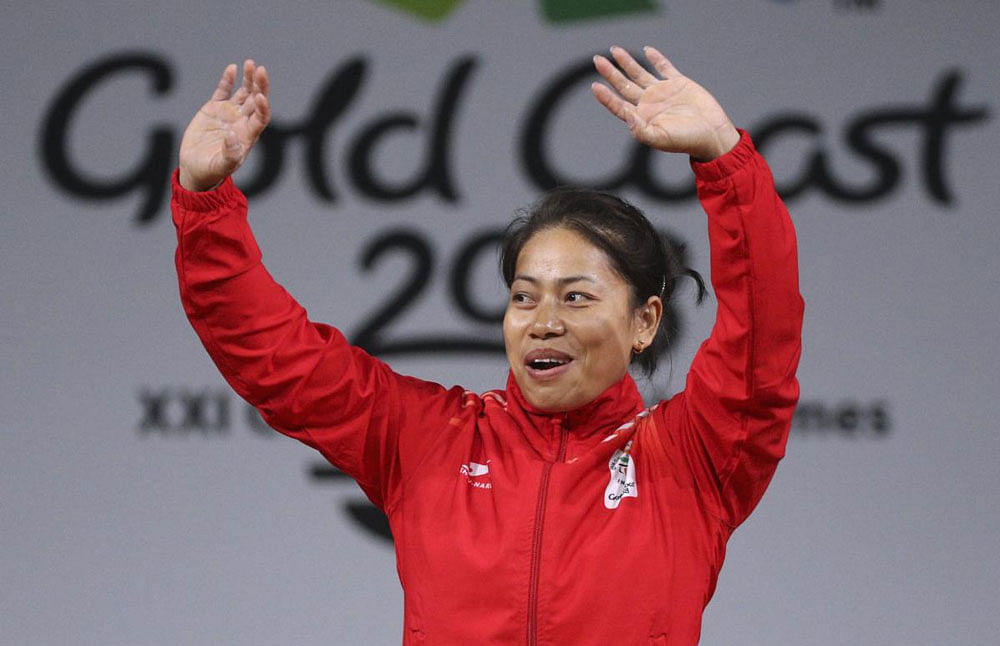 Gold medallist Sanjita Chanu Khumukcham waves during the medal ceremony. Reuters photo.