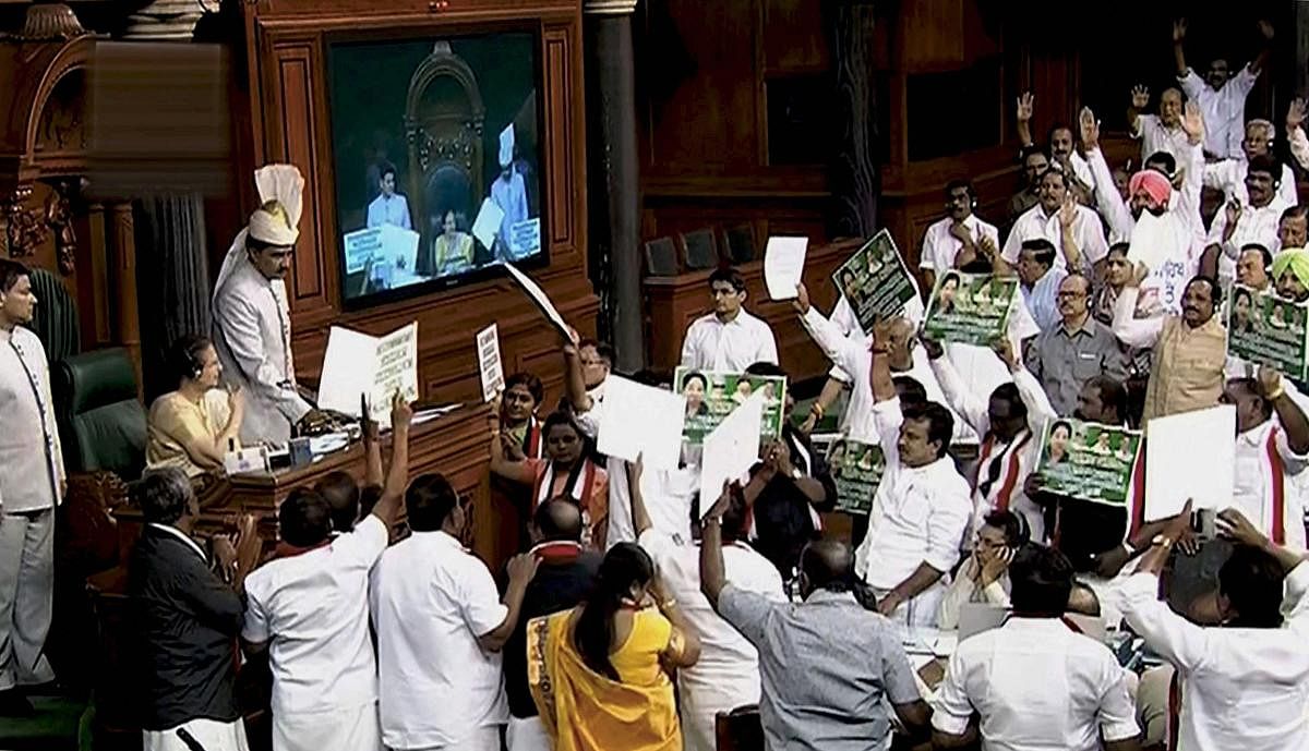 AIADMK members protest in the well of Lok Sabha in New Delhi on Thursday. PTI Photo