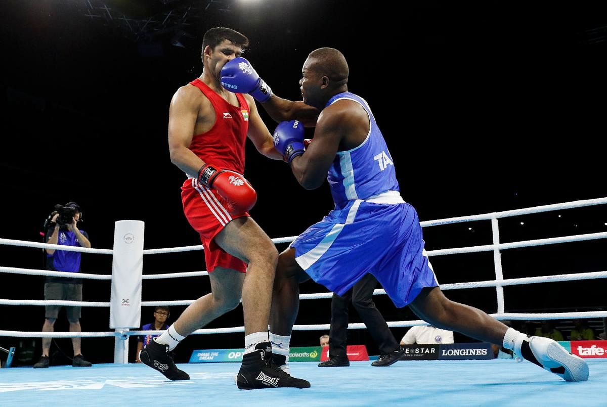 Tanzania's Haruna Mhando (right) lands a punch on India's Naman Tanwar during the men's heavyweight (91Kg) category boxing bout on Friday. AFP