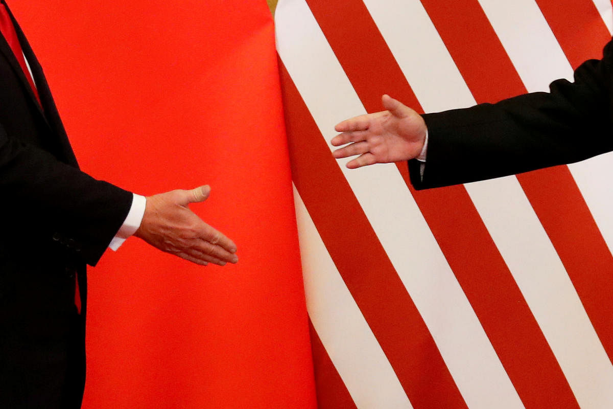 US President Donald Trump yesterday ramped up his trade war rhetoric with China, seeking USD 100 billion in additional tariffs on Chinese products. In picture: U.S. President Donald Trump and China's President Xi Jinping shake hands after making joint statements at the Great Hall of the People in Beijing, China, November 9, 2017. REUTERS