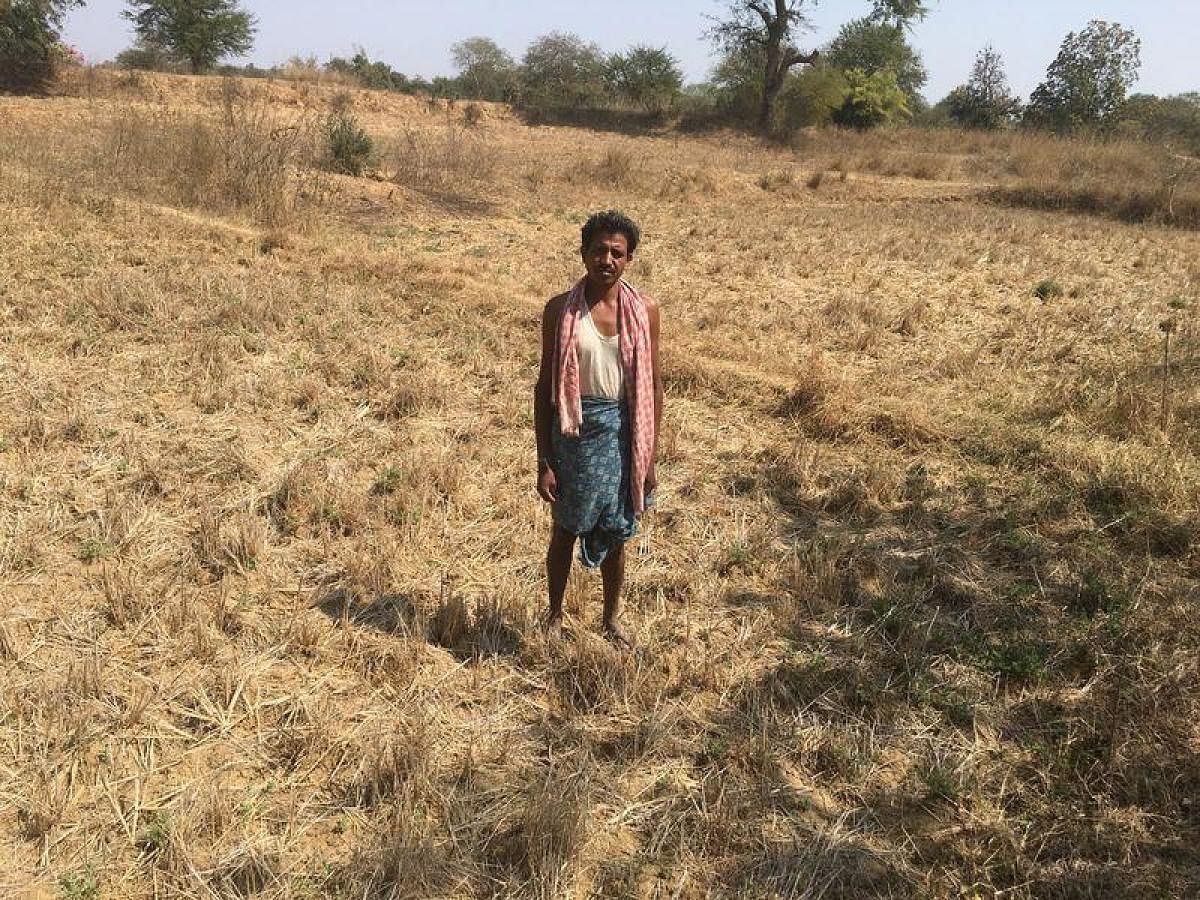 Kumar Gwal poses for a photo on his dry farmland in the drought-hit Kharkhara village in Odisha. Reuters