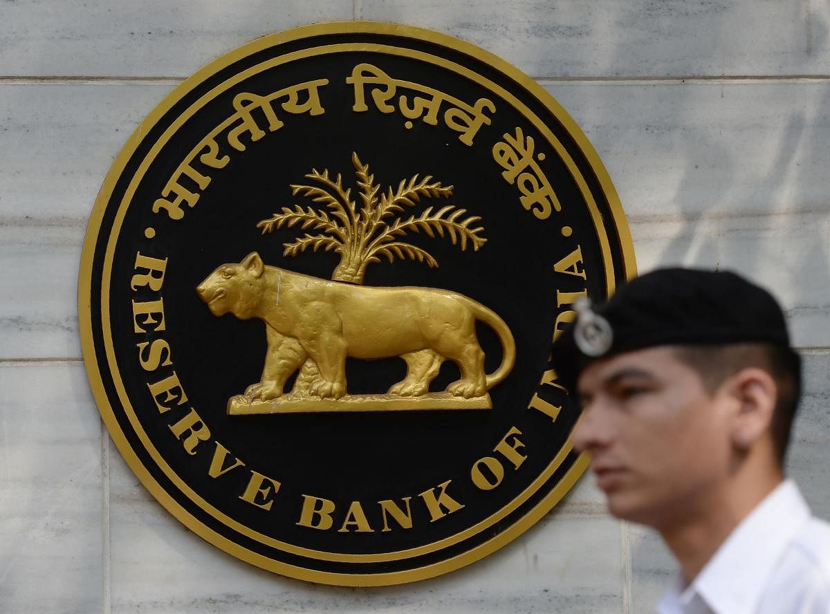 An Indian navy officer walks past the entrance of the Reserve Bank of India (RBI) head office in Mumbai on April 5, 2018. India's central bank on April 5 kept interest rates at a seven-year-low despite a slowdown in inflation and a recent spurt in economic growth. The Reserve Bank of India (RBI) said the benchmark repo rate -- the level at which it lends to commercial banks --- would remain unchanged at 6.0 percent. / AFP PHOTO / PUNIT PARANJPE
