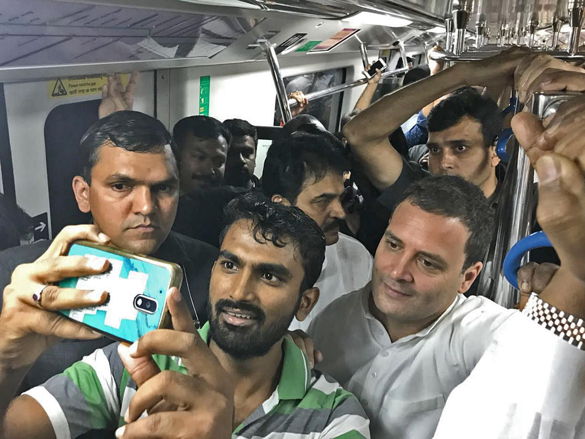 Congress president Rahul Gandhi poses for a selfie with a commuter in Namma Metro on Sunday. Pic:KPCC