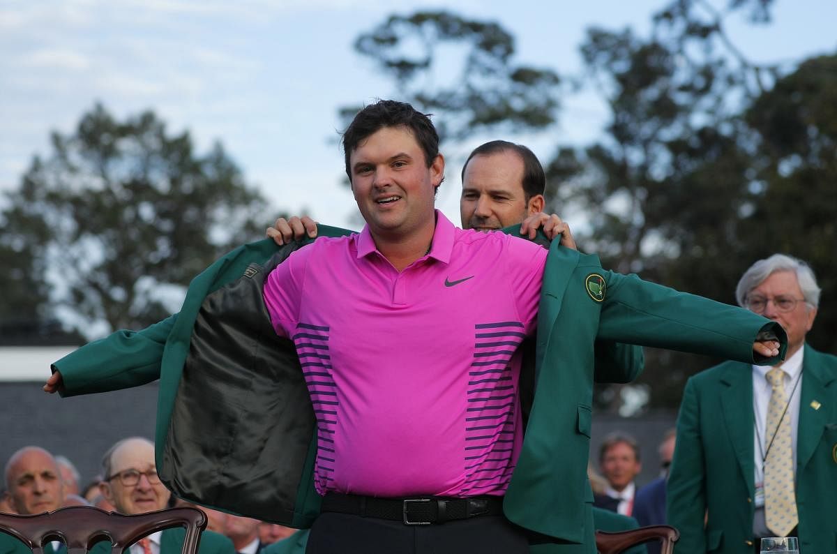 PROUD MOMENT: Sergio Garcia of Spain, last year's Masters' champion, helps put the winner's Green Jacket Patrick Reed at the Augusta Masters on Sunday. REUTERS