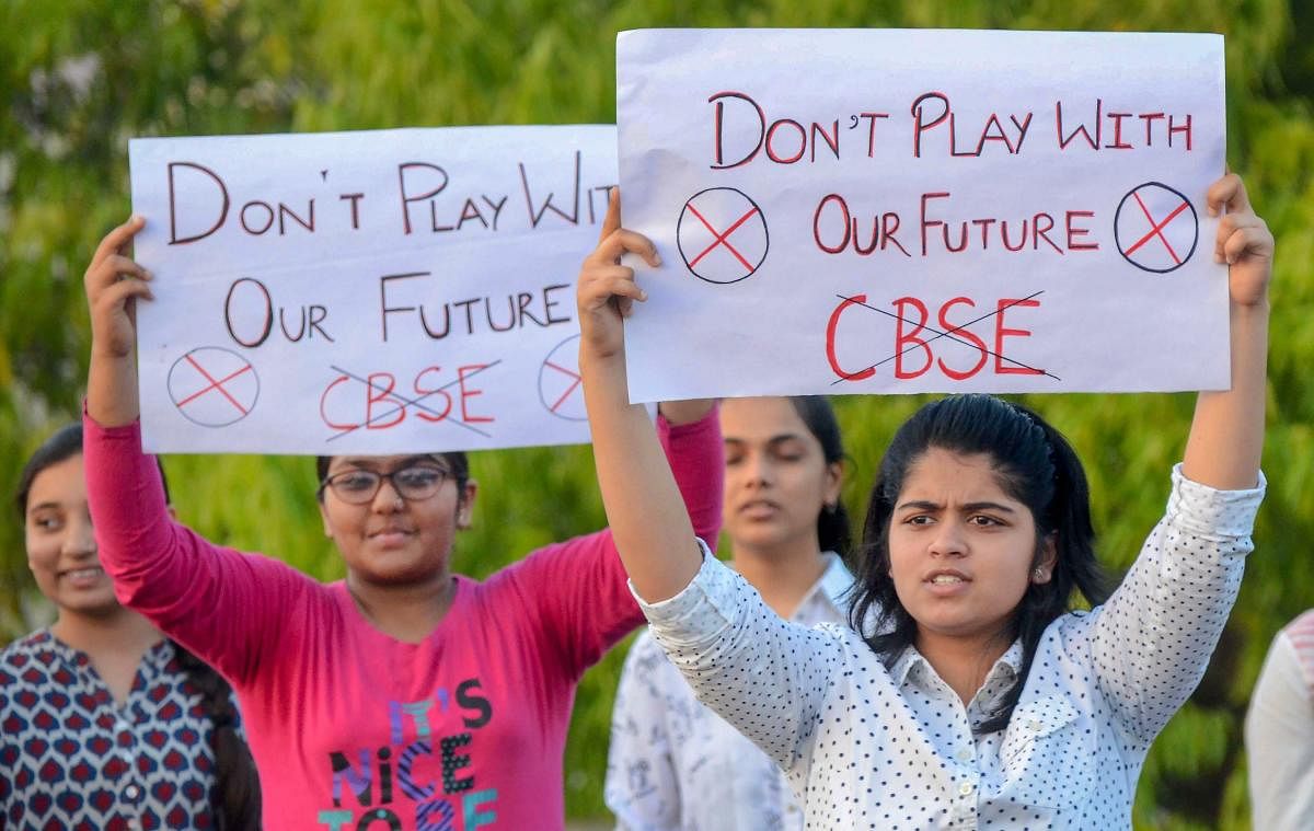 Central Board of Secondary Education (CBSE) students display placards during a protest over the alleged paper leak, in Jabalpur on Friday. PTI file photo.