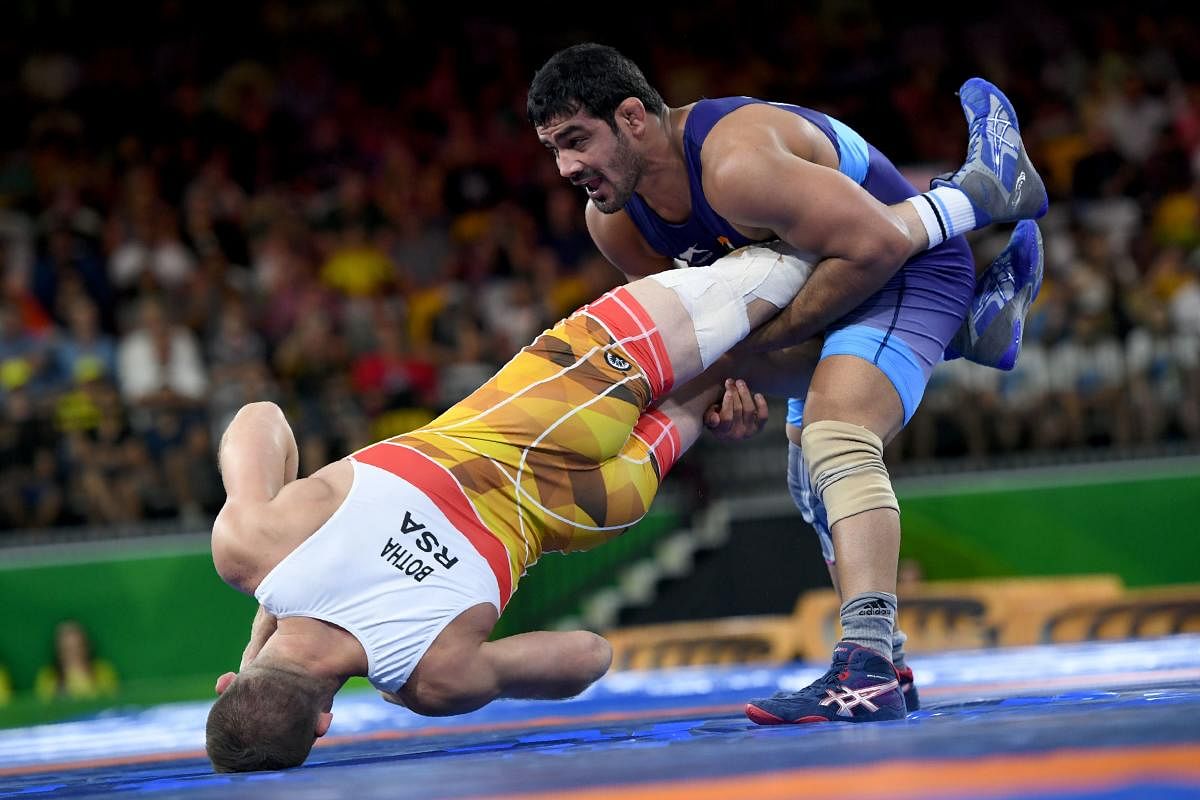 TWISTER: India's Kumar Sushil (blue) wrestles South Africa's Johannes Botha during the 74kg category final of the Commonwealth Games wrestling on Thursday. AFP