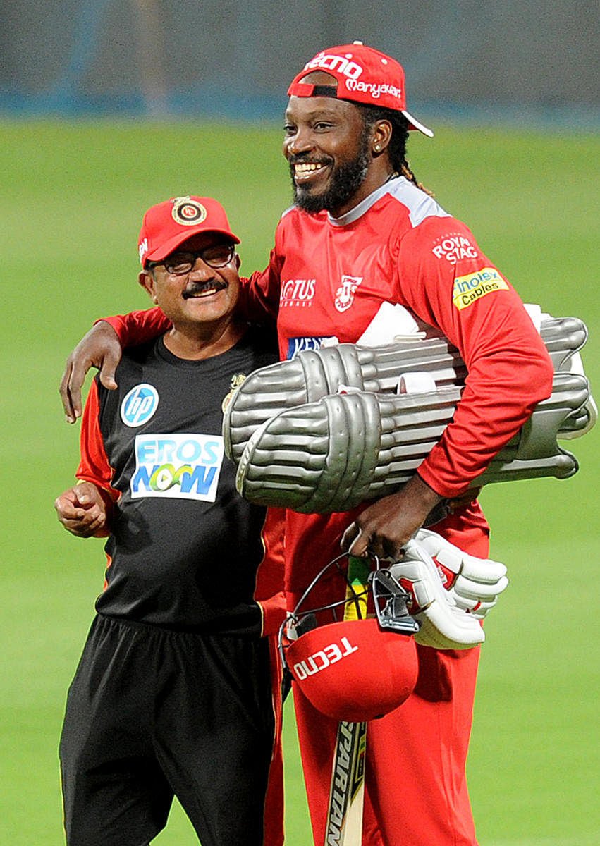 Kings XI Punjab's Chris Gayle with RCB's logistic manager Rajeshwar during a practice session on Wednesday. DH photo Srikanta Sharma R