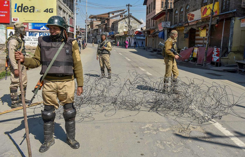 Police stand guard during curfew-like restrictions in Srinagar following the Kathua case. PTI photo.