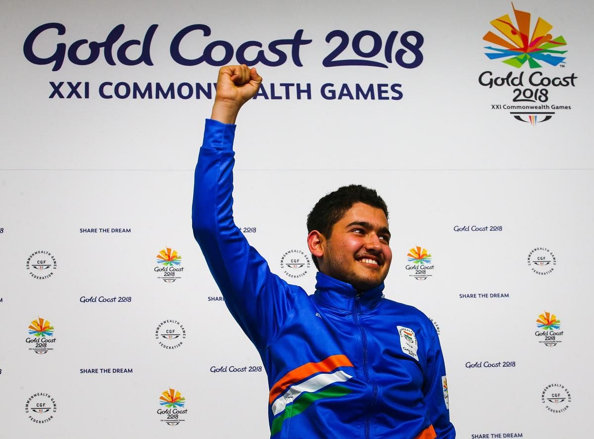 India's Anish celebrates on the podium after winning the men's 25m rapid fire pistol shooting final during the 2018 Gold Coast Commonwealth Games at the Belmont Shooting Complex in Brisbane on April 13, 2018. / AFP PHOTO / Patrick HAMILTON