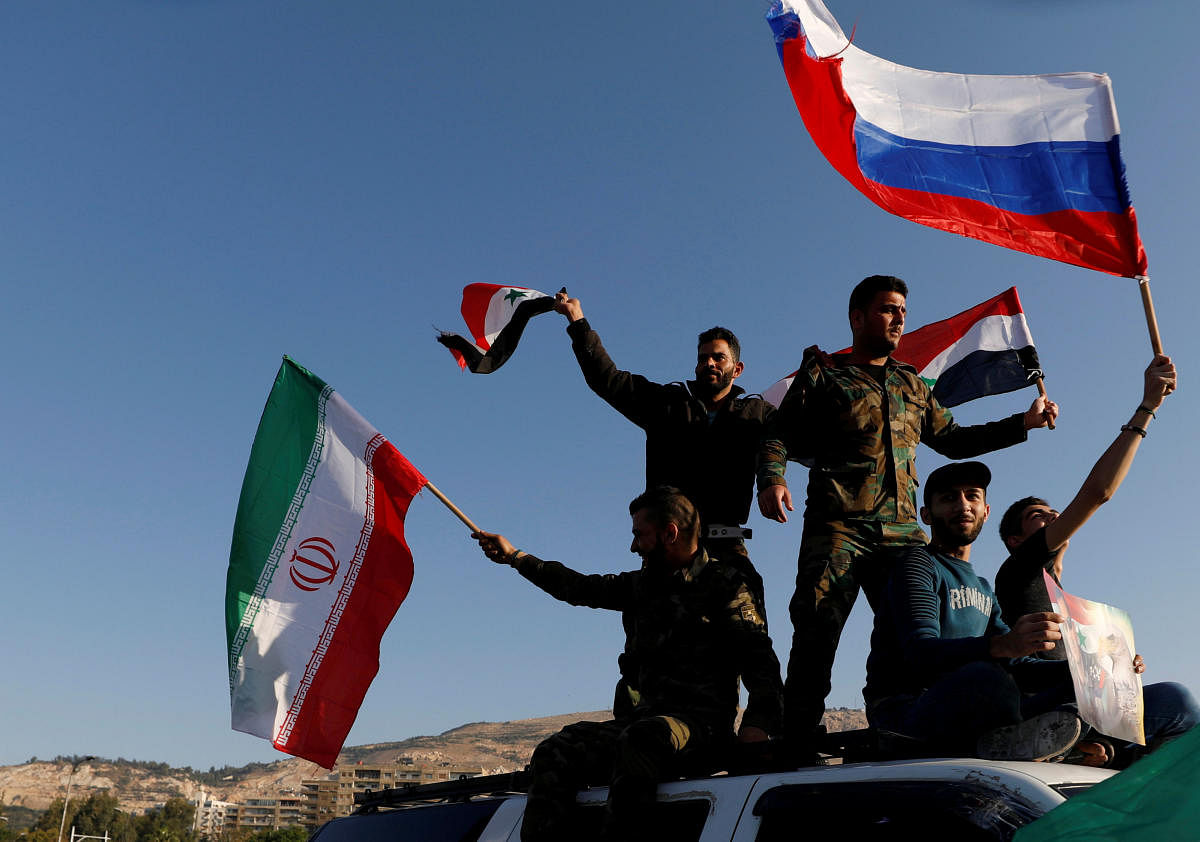 Syrians wave Iranian, Russian and Syrian flags during a protest against U.S.-led air strikes in Damascus,Syria April 14,2018.REUTERS Photo
