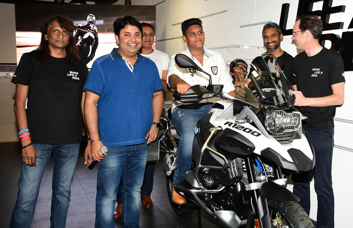 Hans Christian Bantel, CFO BMW India, (extreme right) delivering 100th bike in Bengaluru on Saturday. MD of Tusker BMW Kumar Reddy (extreme left) is also seen. (DH Photo)