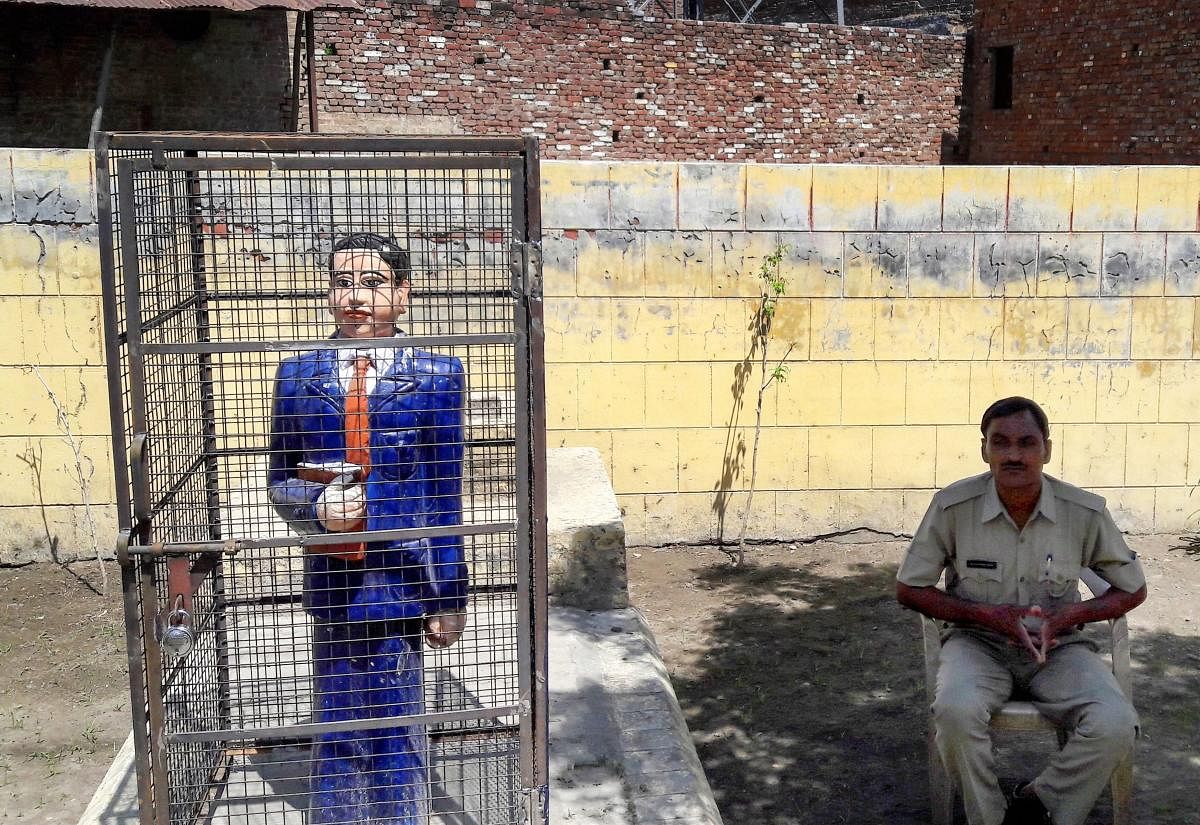 A statue of Dr Bhimrao Ambedkar locked in an iron cage, in Badaun on Thursday. PTI Photo