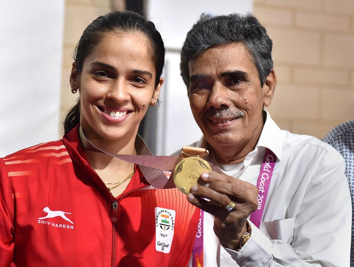 PROUD MOMENT Saina Nehwal with her father Harvir Singh after winning the women's singles gold at the Commonwealth Games. PTI