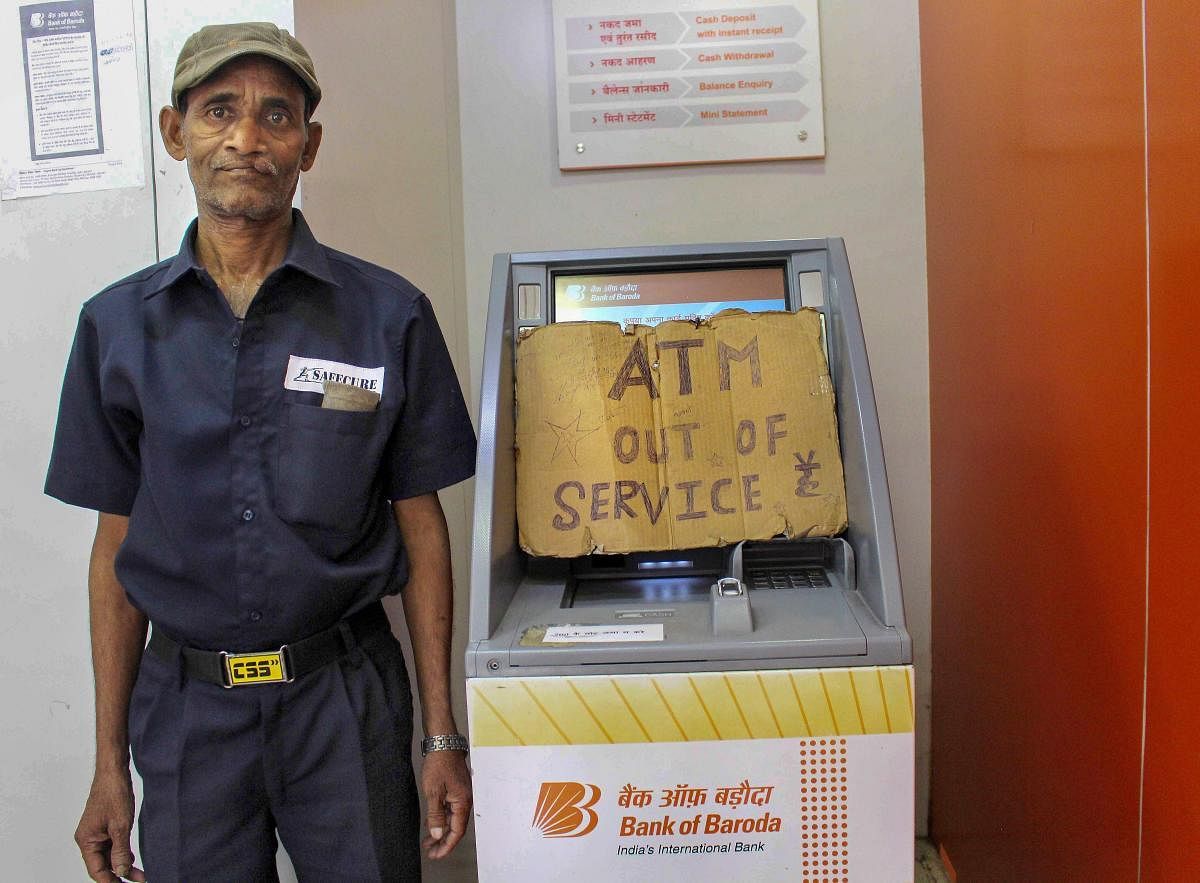  A security guard stands inside an 'out of service ATM' in Bhopal on Tuesday. Most of the ATMs in the city are either out of service or run out of cash. PTI Photo