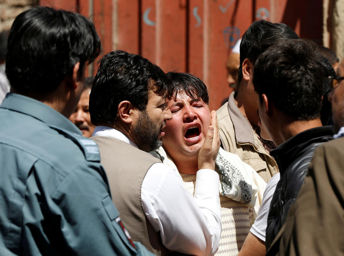 A man reacts as others comfort him at the site of a suicide attack in Kabul, Afghanistan April 22, 2018. REUTERS 