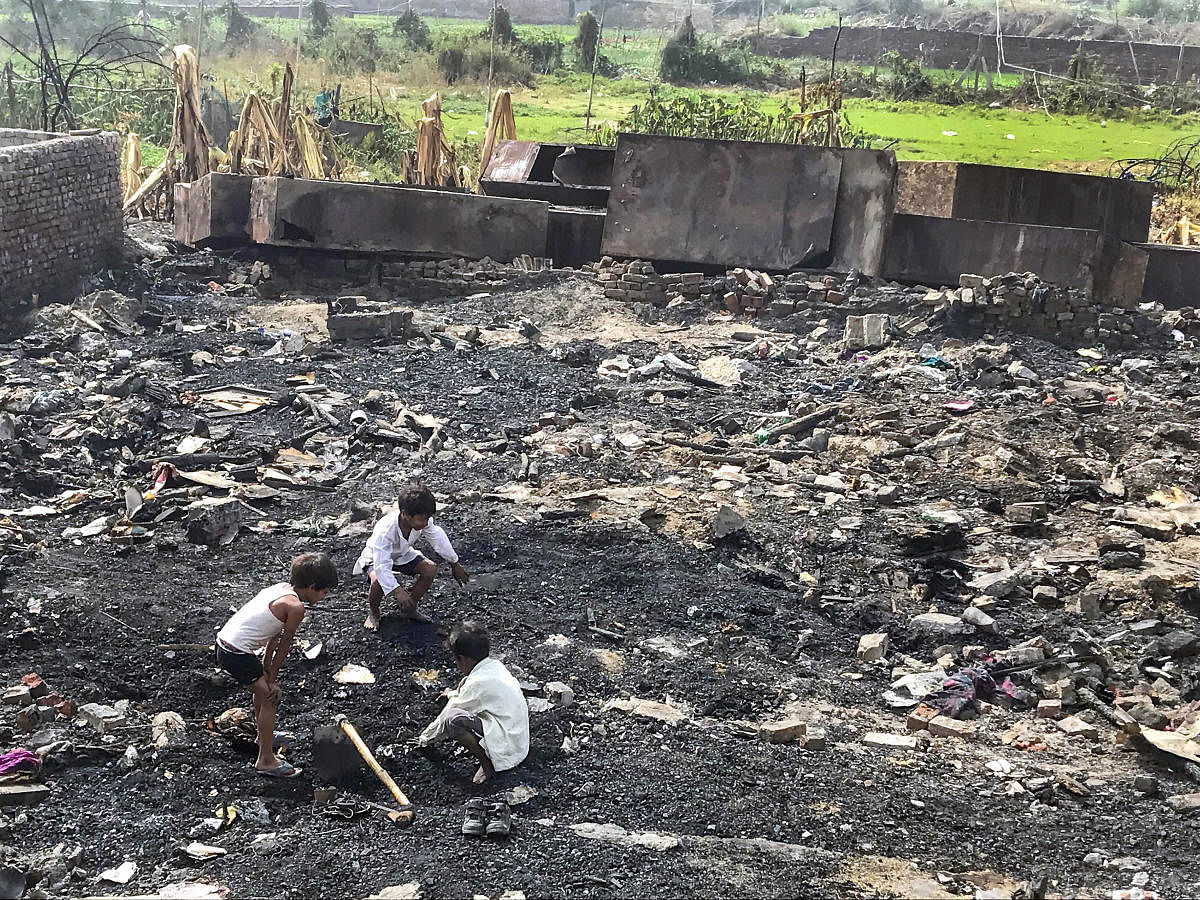 Children searching for their belongings in the charred debris of their homes, a week after a Rohingya camp caught fire in Sarita Vihar in New Delhi. PTI Photo