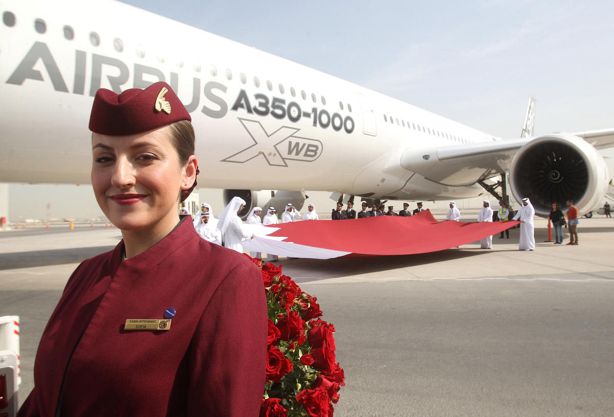 A Qatar Airways flight attendant is seen next to an Airbus A350-1000 in Doha in this file photo.