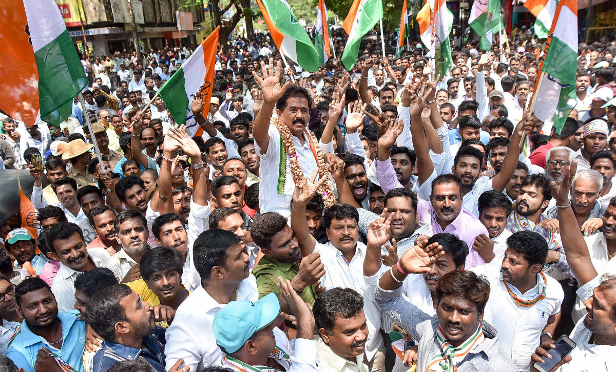 MLA M K Somashekar, Congress candidate of Krishnaraja Assembly segment, waves at his supporters during a procession in Mysuru on Monday.