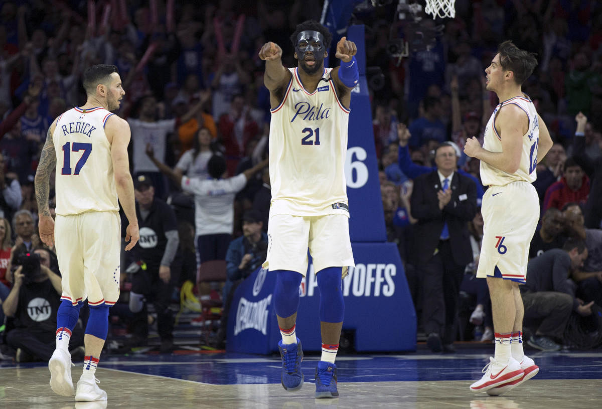 Philadelphia 76ers center Joel Embiid (21) reacts along side guard JJ Redick (17) and guard T.J. McConnell (12) after scoring against the Miami Heat during the fourth quarter in game five of the first round of the 2018 NBA Playoffs at Wells Fargo Center.