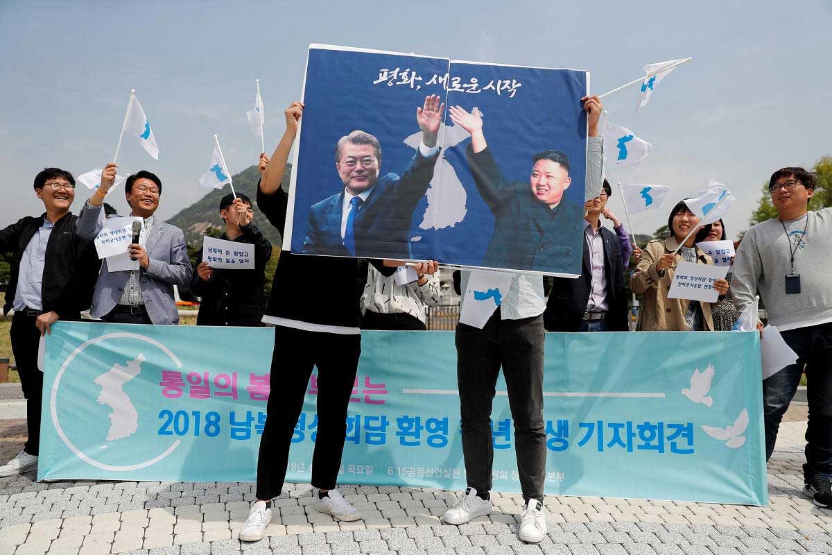 Students hold posters with pictures of South Korea's President Moon Jae-in and North Korea's leader Kim Jong Un during a pro-unification rally ahead of the upcoming summit between North and South Korea in Seoul, South Korea. REUTERS File 