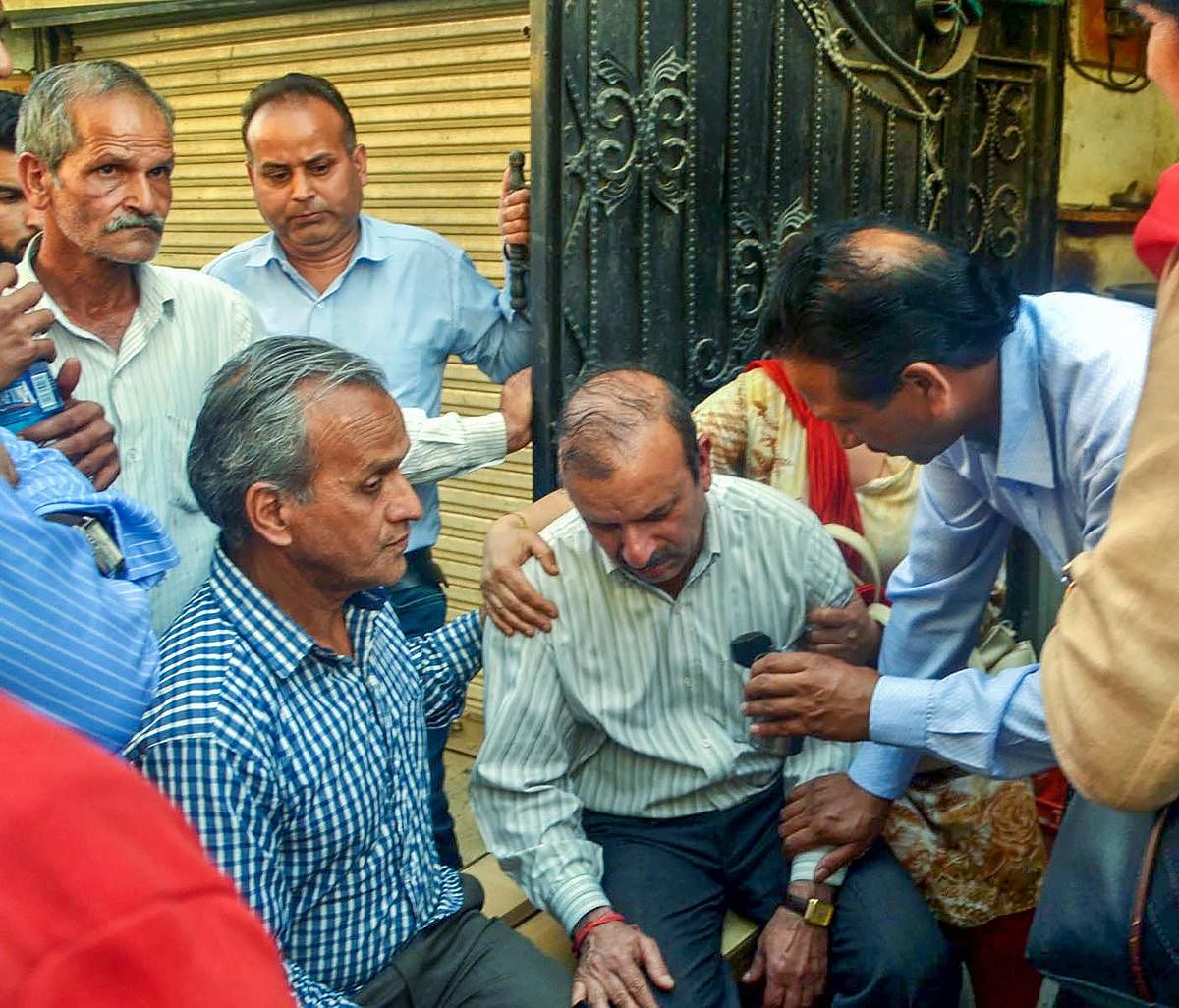Husband of officer Shail Bala Sharma mourns after she was allegedly shot dead by a hotel owner in Kasauli town, where Sharma had yesterday gone to supervise the demolition of unauthorised construction, in Mandi on Wednesday. PTI Photo
