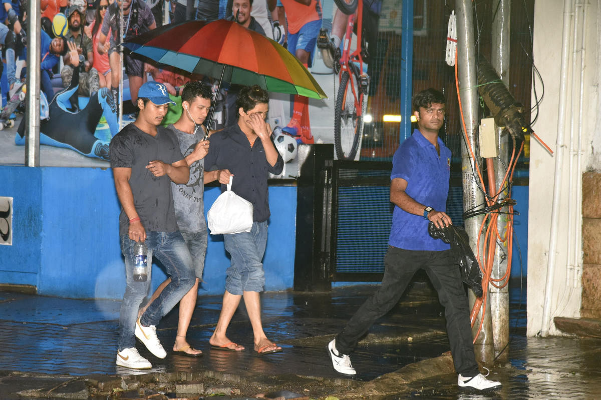 People using umbrella to protect from rain in Bengaluru on Thursday. DH Photo