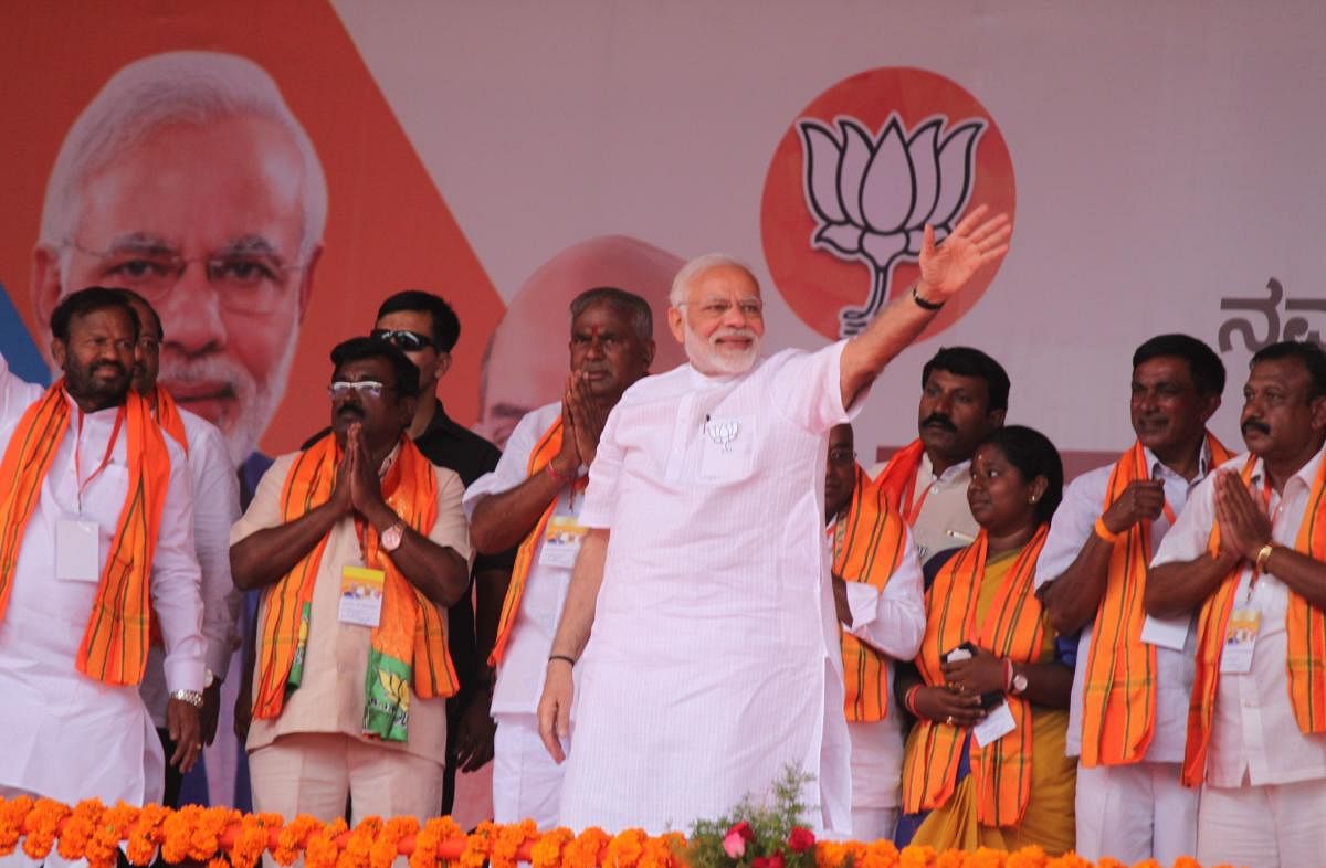 Prime Minister Narendra Modi waves at people at an election campaign at Beerandahalli in Bangarpet taluk in Kolar district. DH photo