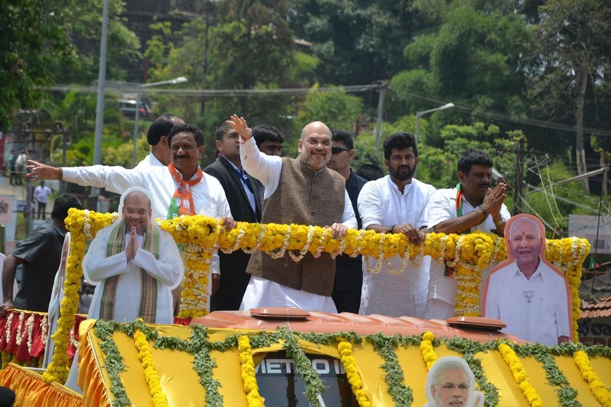 BJP National President Amit Shah took along with BJP candidates from Kodagu M P Appachu Ranjan and K G Bopaiah take out a road show, in Madikeri on Tuesday.