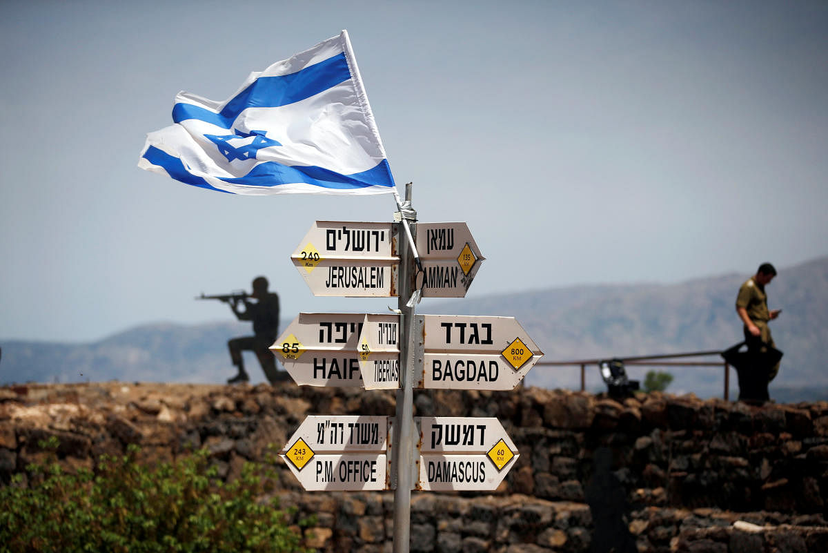 An Israeli soldier stands next to signs pointing out distances to different cities, on Mount Bental, an observation post in the Israeli-occupied Golan Heights that overlooks the Syrian side of the Quneitra crossing, Israel. REUTERS Photo