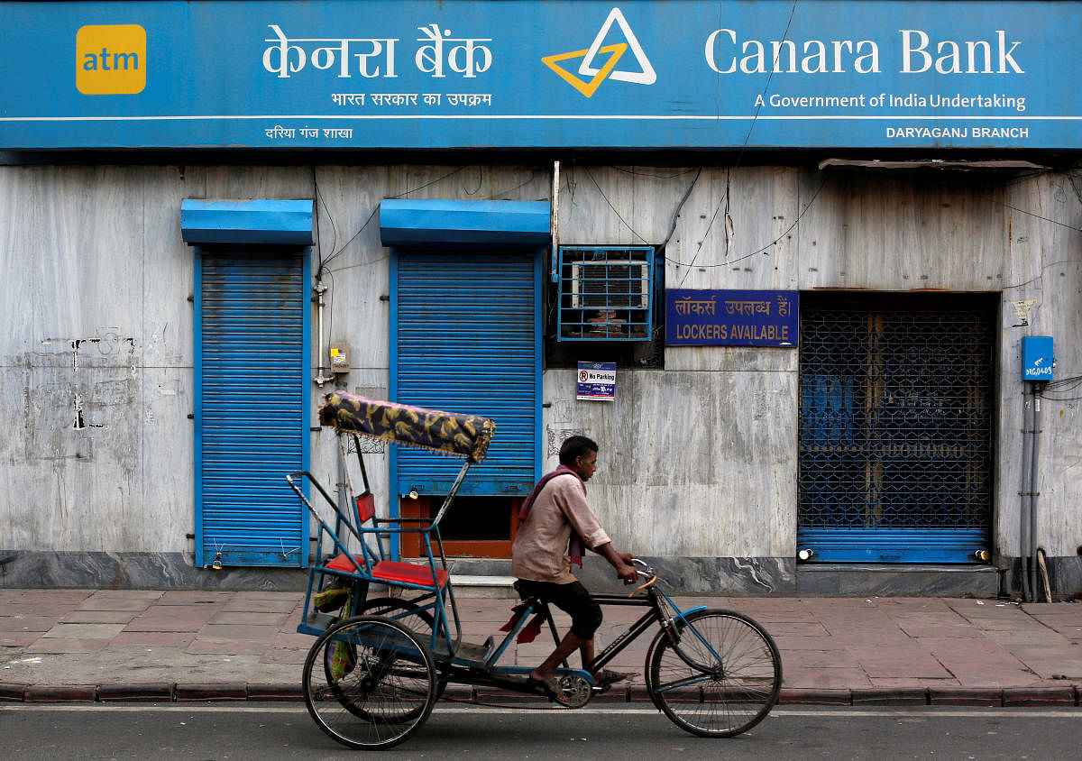 FILE PHOTO - A rickshaw puller passes the Canara Bank branch in the old quarters of Delhi, India, September 6, 2017. REUTERS
