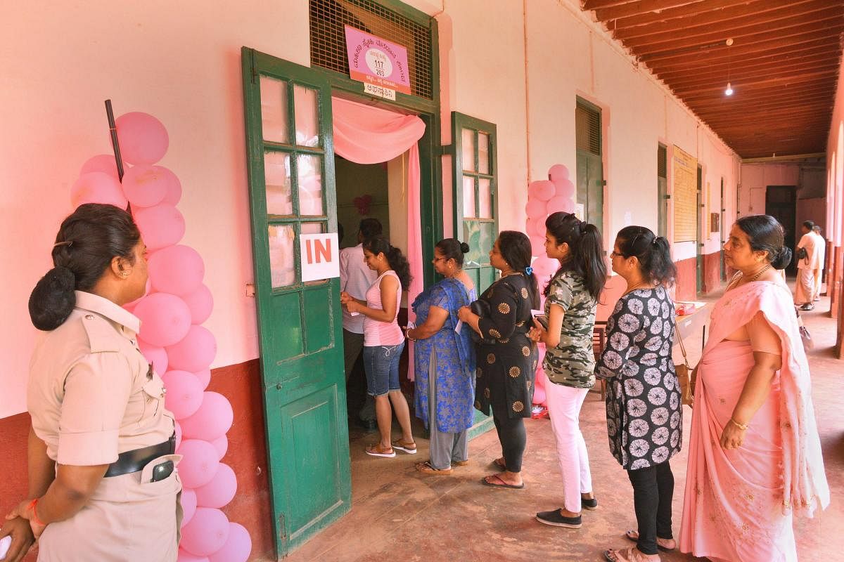 Voters stand in a queue to cast their votes for Karnataka Assembly election 2018 at a polling station in Mangaluru on Saturday. PTI Photo