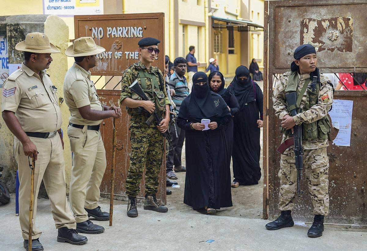 Mizoram Armed Police stand guard as voters leave after casting their ballot for the Karnataka Assembly election 2018 in Bengaluru on Saturday. PTI photo
