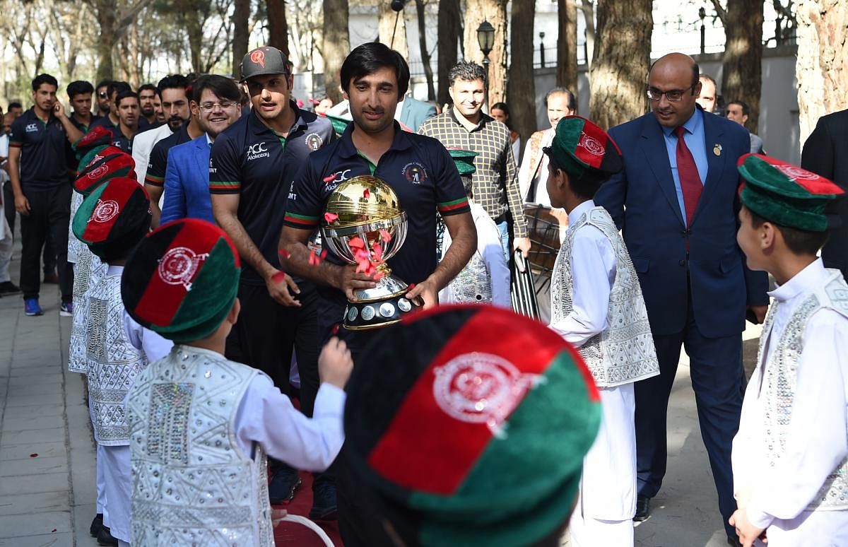 Afghan cricket captain Asghar Stanikzai (C) and teammate Mohammed Nabi (C-L) arrive for an event to celebrate the Afghan national team qualification to the 2019 cricket World Cup in Kabul on March 27, 2018. Afghanistan's cricket team received a hero's wel