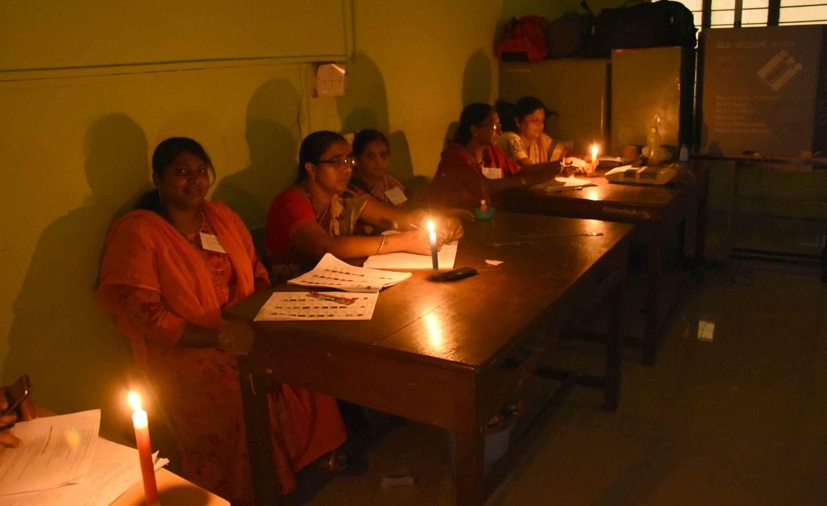As power supply was severely affected in some parts of the city and rural areas, poll staff at Government Training Centre at Gandhi Nagar working under candle light.