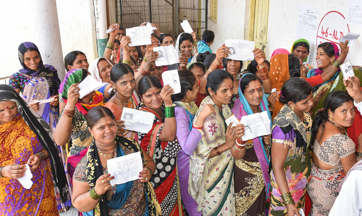 Women stand in Queue to exercise their franchise for Assembly Election at Korahalli village in Aland taluk in Kalaburagi District on Saturday.