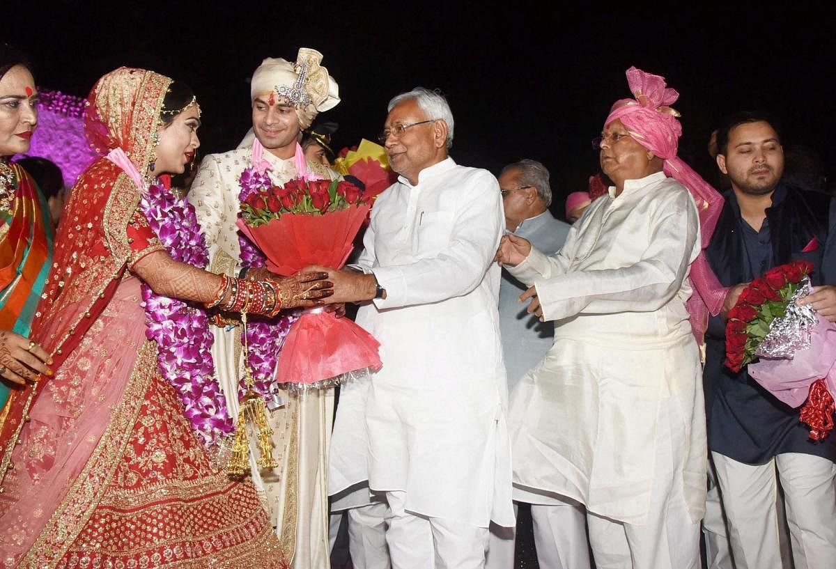 Bihar Chief Minister Nitish Kumar greets RJD chief Lalu Prasad Yadav's latter's elder son Tej Pratap during the wedding ceremony at Veterinary College Ground in Patna on Saturday. PTI Photo