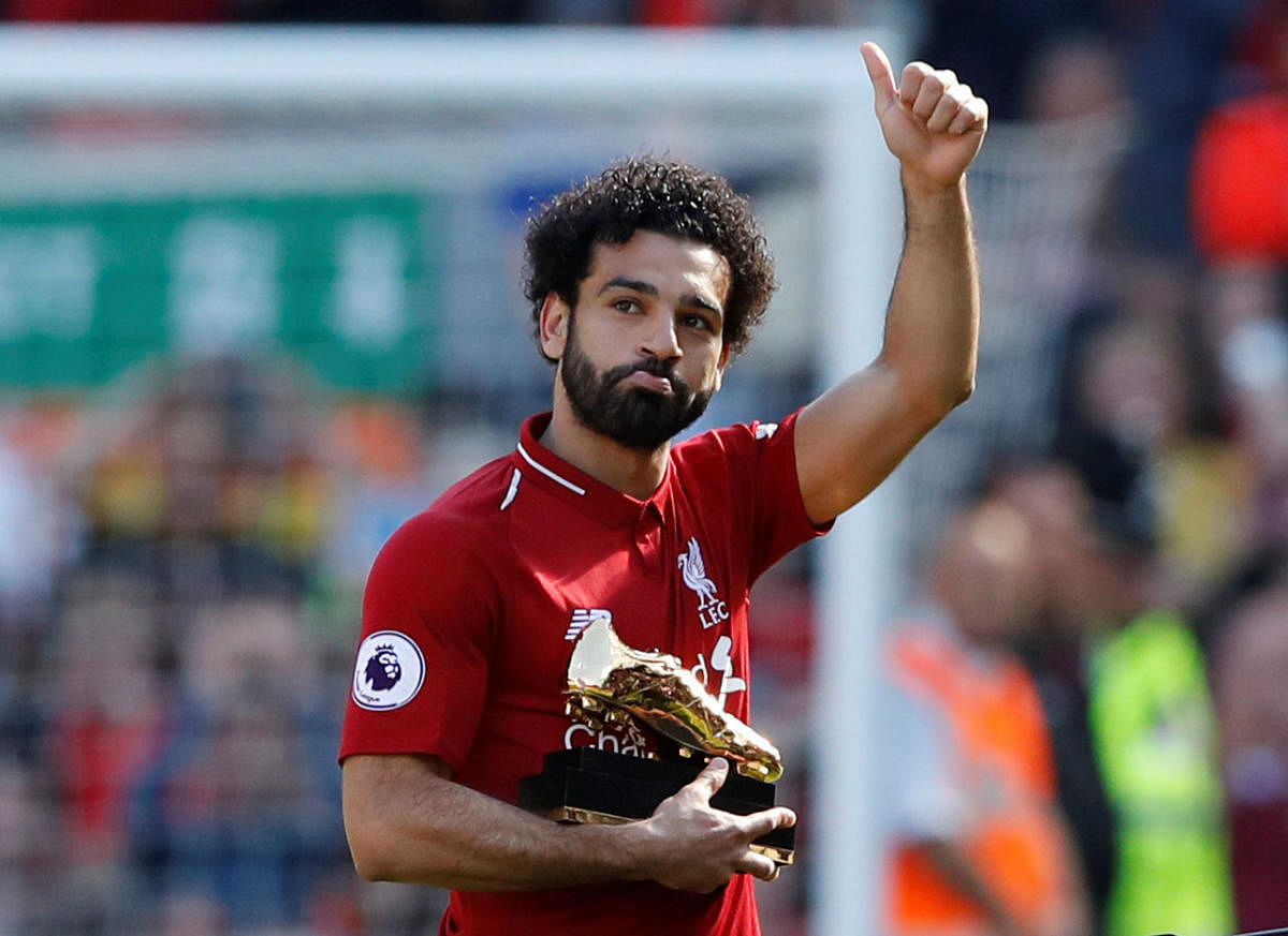 Record breaker: Liverpool's Mohamed Salah celebrates with golden boot after beating Brighton &amp; Hove Albion on Sunday. Reuters