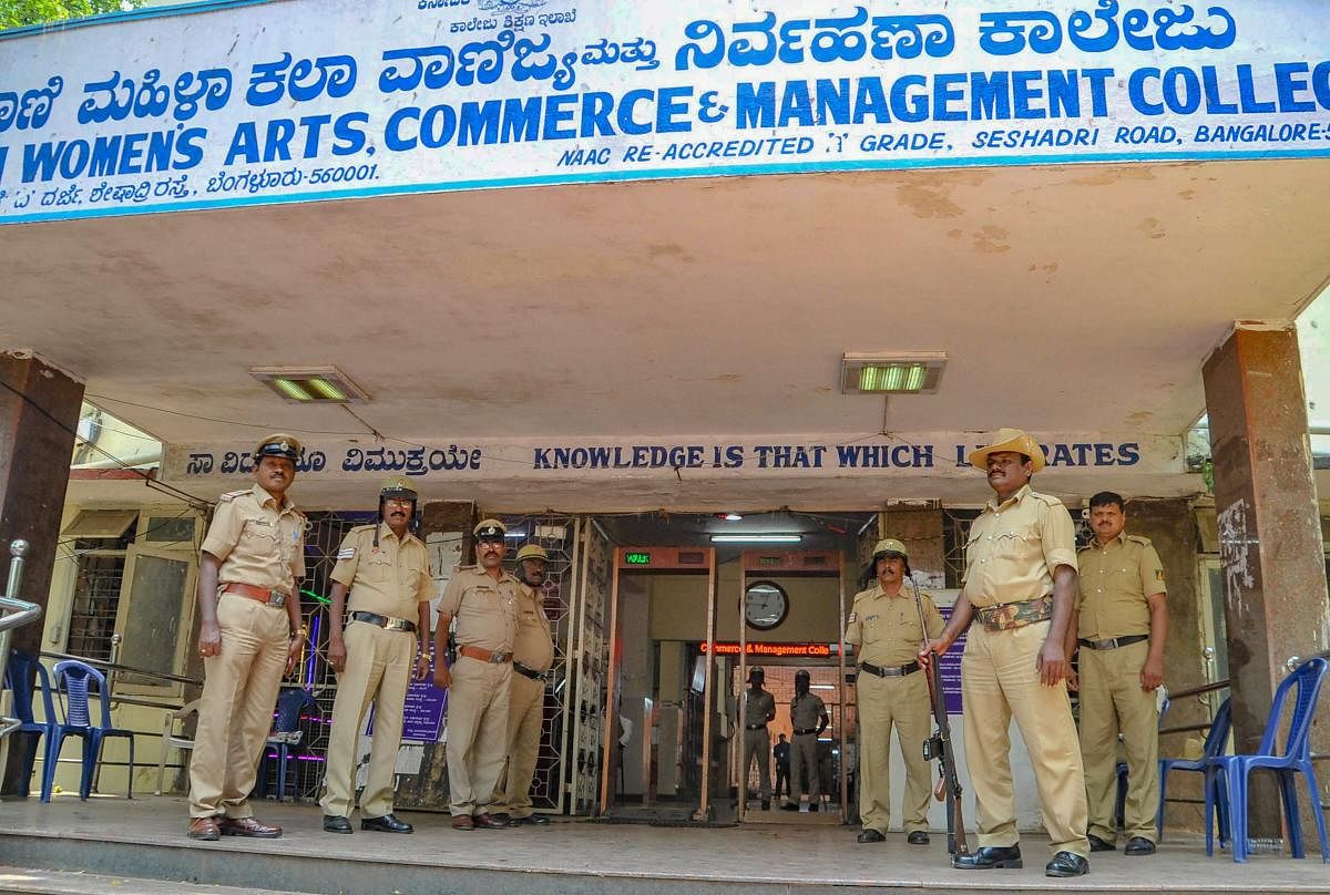 Police personnel stand guard outside a counting centre after the Karnataka Assembly Elections 2018 in Bengaluru on Monday. PTI Photo